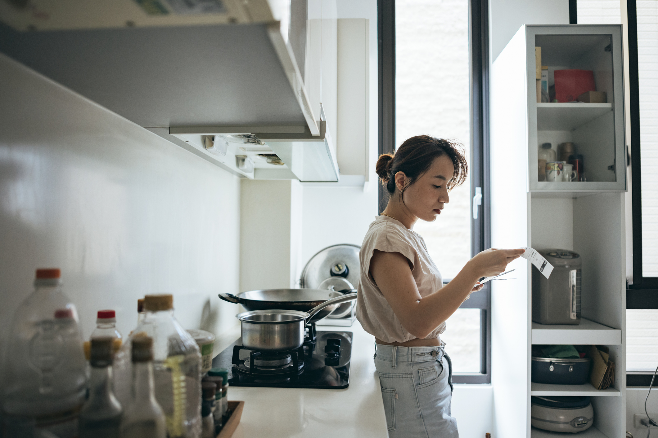 Asian women examining the shopping receipt at home